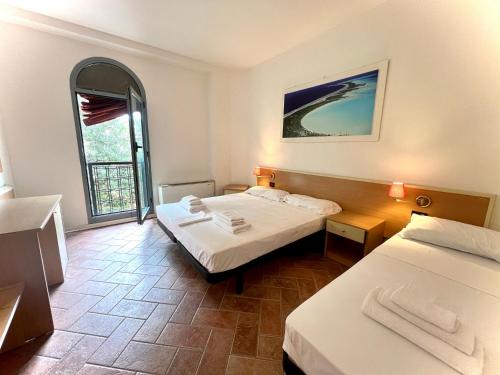 a hotel room with two beds and a window at SAGOSTINO HOUSE in SantʼAgostino