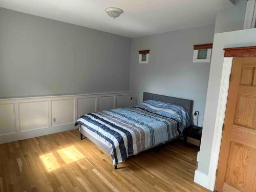 Schlafzimmer mit einem Bett und Holzboden in der Unterkunft Spacious Medford Gem in Medford