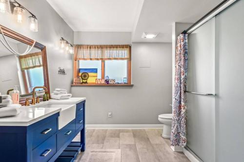 ein Badezimmer mit einem blauen Waschbecken und einem Kühlschrank in der Unterkunft Country Oasis 