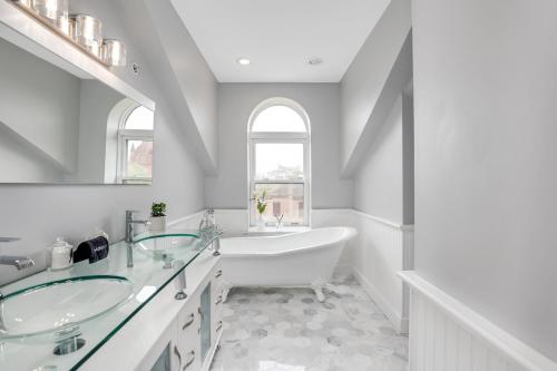 a bathroom with two sinks and a bath tub at The Lumber Baron's Mansion: 2 King Suites, 2.5BA + Gym in Detroit