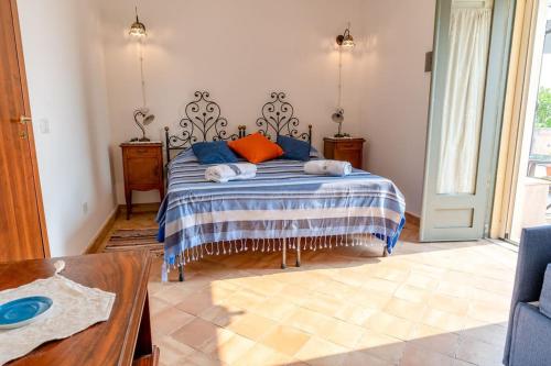 a bedroom with a bed with blue and orange pillows at Le casette di Marò in Nunziata