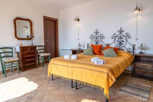 um quarto com uma cama grande e almofadas laranja em Le casette di Marò em Nunziata