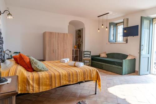 a bedroom with a bed and a couch at Le casette di Marò in Nunziata