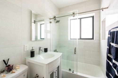 a white bathroom with a sink and a shower at Cozy Place in Miami