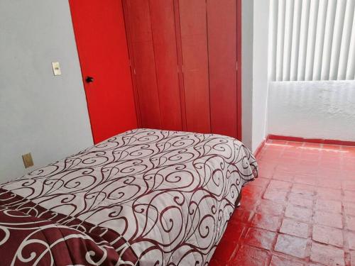 a bedroom with a black and white bed with a red door at Casa completa en Zapopan in Guadalajara