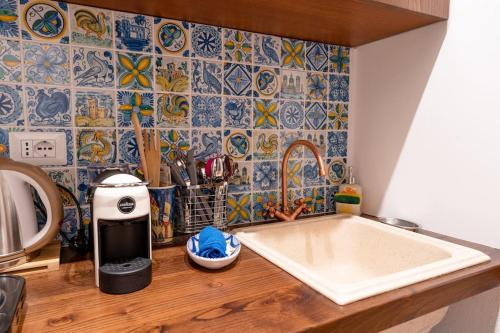 cocina con fregadero y pared de azulejos en Le casette di Marò, en Nunziata