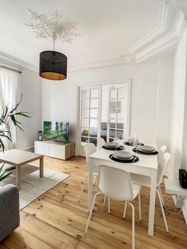 a white dining room with a white table and chairs at Grand Cozy appart - proche métro Paris - spots touristiques in Ivry-sur-Seine