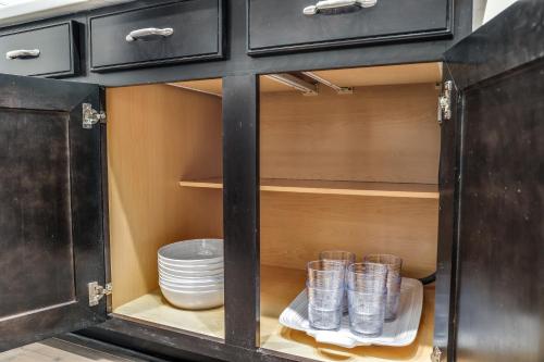 a black cabinet with plates and cups in it at The Lumber Baron's Mansion: 2 King Suites, 2.5BA + Gym in Detroit