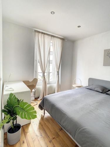 Schlafzimmer mit einem Bett, einem Schreibtisch und einem Fenster in der Unterkunft Grand Cozy appart - proche métro Paris - proche spots touristiques in Ivry-sur-Seine