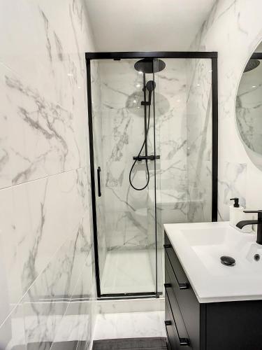a white bathroom with a shower and a sink at Grand Cozy appart - proche métro Paris - spots touristiques in Ivry-sur-Seine