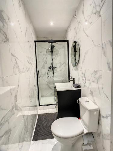a white bathroom with a toilet and a shower at Grand Cozy appart - proche métro Paris - spots touristiques in Ivry-sur-Seine