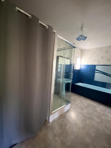 une salle de bain avec une douche en verre et une baignoire dans l'établissement Maison au calme, 6 voyageurs, à Riorges