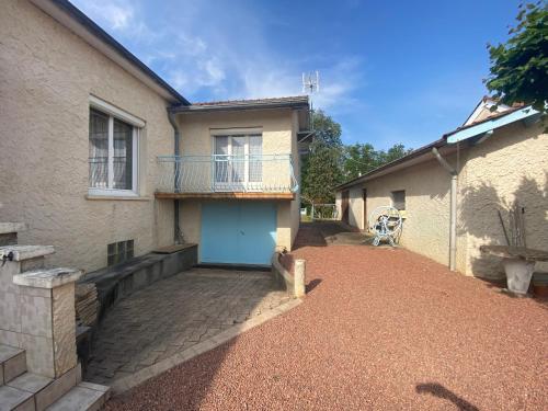 ein Haus mit einer blauen Tür und einer steinernen Einfahrt in der Unterkunft Maison au calme, 6 voyageurs in Riorges