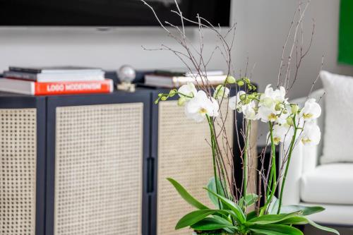 a vase with white flowers in a living room at The Lumber Baron's Mansion: 2 King Suites, 2.5BA + Gym in Detroit