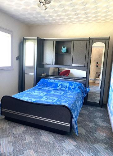 une chambre avec un lit avec une couette bleue dans l'établissement Maison au calme, 6 voyageurs, à Riorges
