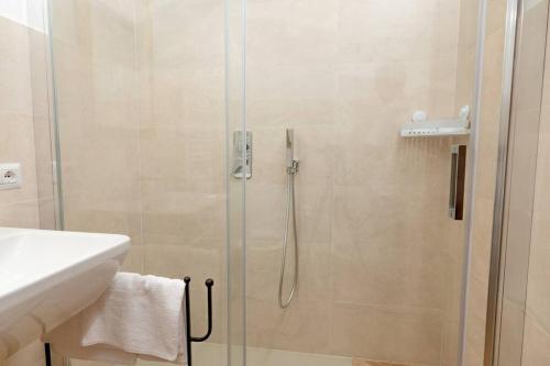 a shower with a glass door next to a sink at Le casette di Marò in Nunziata
