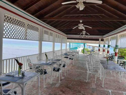 un restaurante con mesas y sillas en la playa en Beachfront Luxe Apt en Runaway Bay