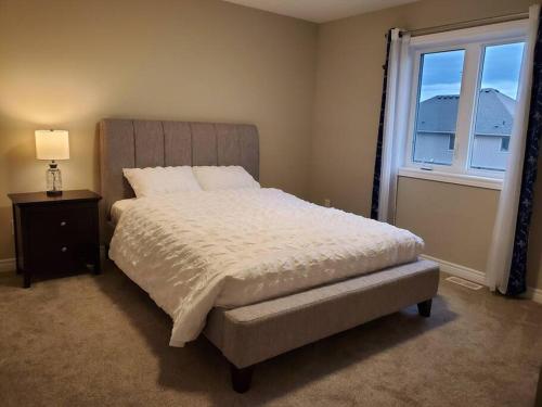 a bedroom with a large bed and a window at 4 BD Family Retreat - Basement not Included in Stratford