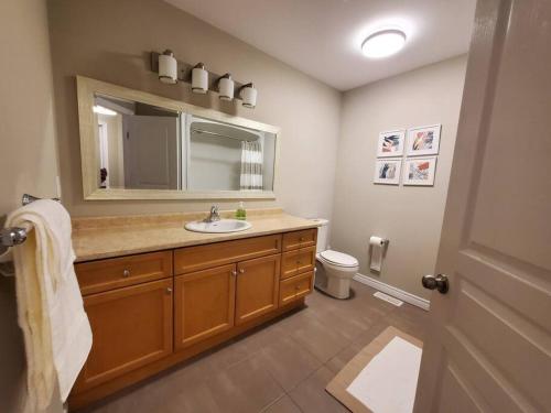 a bathroom with a sink and a mirror at 4 BD Family Retreat in Stratford