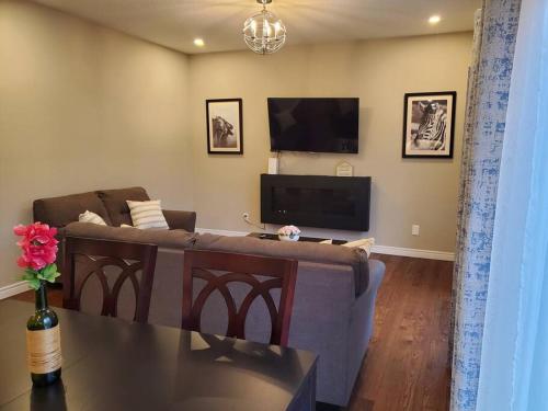 a living room with a couch and a flat screen tv at 4 BD Family Retreat in Stratford
