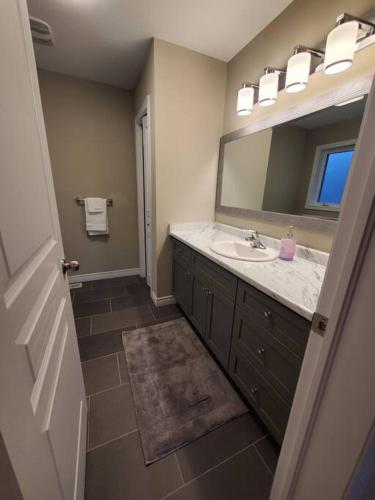 a bathroom with a sink and a mirror at 4 BD Family Retreat - Basement not Included in Stratford