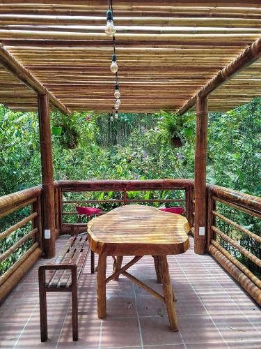a wooden table and bench on a wooden deck at Senz Glamping - Mindo in Mindo