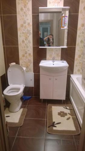 a bathroom with a toilet and a sink and a mirror at Apartments KING in Poznań