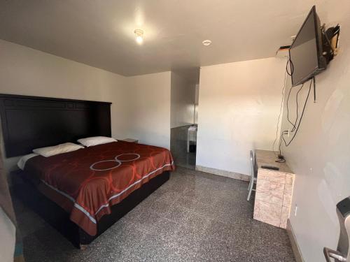 サンアントニオにあるSunrise Motel San Antonioのベッドルーム(ベッド1台、薄型テレビ付)