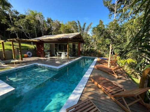 a swimming pool with chairs and a gazebo at Refúgio Integração in Mata de Sao Joao