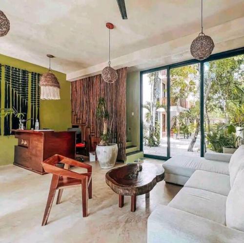 ein Wohnzimmer mit einer weißen Couch und einem Klavier in der Unterkunft Apartment with private pool Tulum in Chemuyil