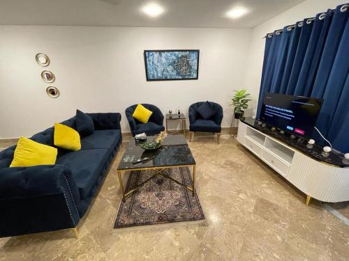 a living room with a blue couch and a television at Apartment in Islamabad F-10 in Rawalpindi