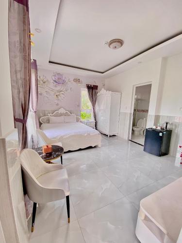 a large white bedroom with a bed and a table at Godiva Villa Phu Quoc in Phu Quoc