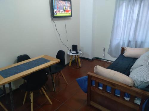 sala de estar con mesa y sofá en Departamento céntrico, en Mendoza