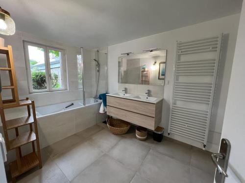 W łazience znajduje się umywalka, wanna i lustro. w obiekcie La Giraudière w mieście Cellettes