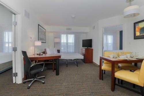 a hotel room with a desk and chairs and a table at Residence Inn by Marriott Arlington South in Arlington