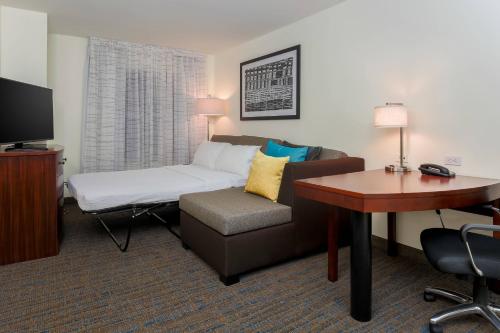 Pokój hotelowy z kanapą, biurkiem i łóżkiem w obiekcie Residence Inn by Marriott Arlington South w mieście Arlington