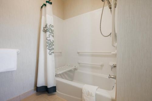 a white bathroom with a tub and a shower curtain at Residence Inn by Marriott Arlington South in Arlington