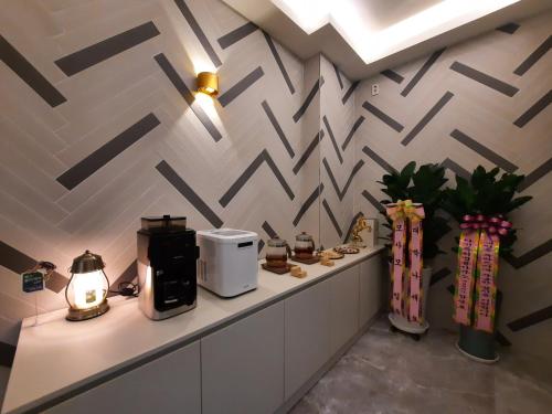 a room with a counter with a coffee maker and vases at Rein Hotel Busan Yeonsan in Busan