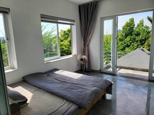 a bedroom with a bed in a room with windows at Tranquil Retreat Lux Villa in HungYen Countryside in HÆ°ng YÃªn