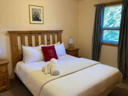 a bedroom with a large white bed with red pillows at Chalet L'Érable Mont-Tremblant/Lac Supérieur & SPA in Lac-Superieur