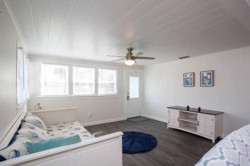 a bedroom with a bed and a ceiling fan at Bright, Immaculate and Cozy Coastal Cottage in Ozona in Palm Harbor