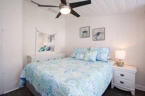 a bedroom with a bed with a blue comforter at Bright, Immaculate and Cozy Coastal Cottage in Ozona in Palm Harbor