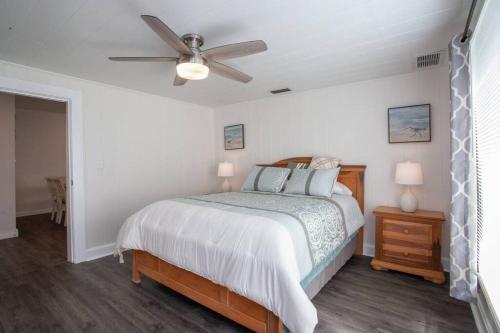 a bedroom with a bed and a ceiling fan at Bright, Immaculate and Cozy Coastal Cottage in Ozona in Palm Harbor