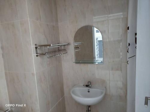 La salle de bains est pourvue d'un lavabo et d'un miroir. dans l'établissement Apartemen Skylounge Makassar, à Manda