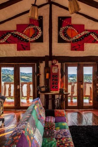 a living room with a couch in a room with windows at Las Margaritas Salento in Salento