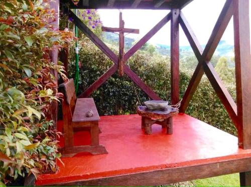 a porch with a cross and a bench and a crossurrectionurrectionurrectionurrectionurrection at Las Margaritas Salento in Salento