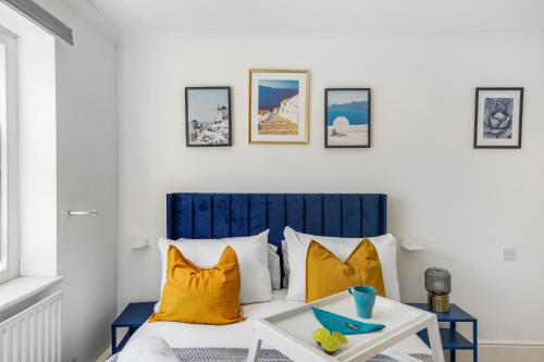Un dormitorio con una cama con almohadas amarillas y una mesa. en LiveStay - Apartments in Bayswater London, en Londres
