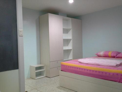 1 dormitorio con 1 cama y armario blanco en IsYou Sabye ห้องพักรายวัน รามคำแหง, en Ban Zong Katiam