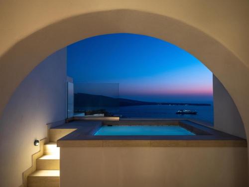 a view of a bath tub with a view of the ocean at Santo Pure Oia Suites & Villas in Oia