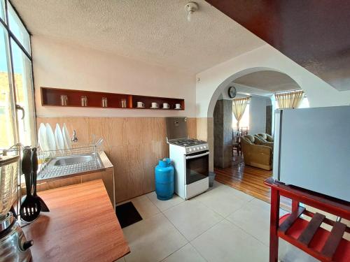 uma cozinha com um lavatório e um frigorífico em Alojamiento Comodo con Vista Espectacular em Riobamba